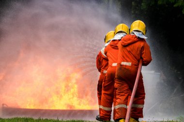 Firefighter Concept. Fireman using water and extinguisher to fighting with fire flame. firefighters fighting a fire with a hose and water during a firefighting training exercise