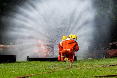 Firefighter Concept. Fireman using water and extinguisher to fighting with fire flame. firefighters fighting a fire with a hose and water during a firefighting training exercise