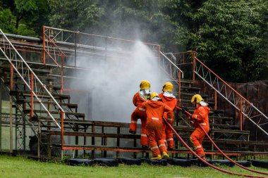 Firefighter Concept. Fireman using water and extinguisher to fighting with fire flame. firefighters fighting a fire with a hose and water during a firefighting training exercise