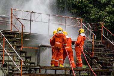 Firefighter Concept. Fireman using water and extinguisher to fighting with fire flame. firefighters fighting a fire with a hose and water during a firefighting training exercise