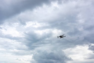 Dijital kamerayla uçan bir helikopter. Yüksek çözünürlüklü dijital kameralı İHA. Uçan kamera bir fotoğraf ve video çek. Profesyonel kameralı İHA puslu dağların fotoğraflarını çekiyor..
