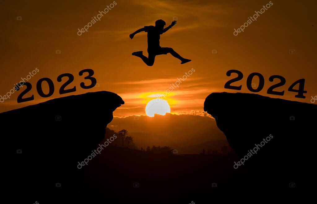 Un hombre joven saltar entre 2023 y 2024 años sobre el sol y a través