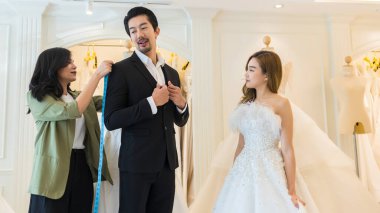 Gelin ve damat gelinlik giyer ve gelinlik mağazası sahibiyle modern düğün stüdyosuna girmeye çalışırlar.