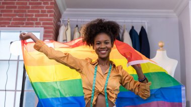 Gururlu gökkuşağı bayrağıyla ayakta duran mutlu kadınlar.