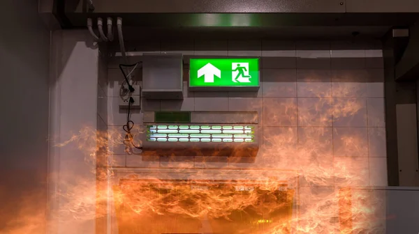 Green emergency exit sign showing the way to escape. Fire exit in the building.