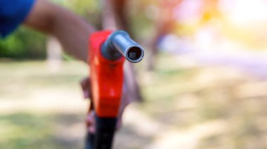 Son bir damla ile gaz hortumu. Doğa arka planında turuncu benzin hortumu. Petrol yakıtını doğanın arka planında doldur ve doldur. Benzin istasyonu, yakıt ikmali. Makineyi yakıtla doldurmak için. 
