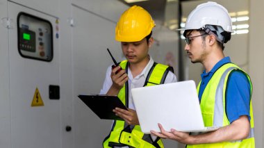 Kontrol odasında çalışan elektrik mühendisi. Elektrik mühendisi kontrol odasındaki güç dağıtım dolabını kontrol ediyor.