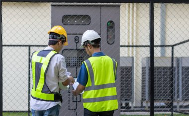 Kontrol odasında çalışan elektrik mühendisi. Elektrik mühendisi kontrol odasındaki güç dağıtım dolabını kontrol ediyor.