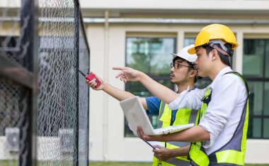 Kontrol odasında çalışan elektrik mühendisi. Elektrik mühendisi kontrol odasındaki güç dağıtım dolabını kontrol ediyor.