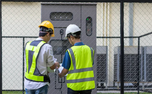 Kontrol odasında çalışan elektrik mühendisi. Elektrik mühendisi kontrol odasındaki güç dağıtım dolabını kontrol ediyor.