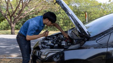 Man is Checking  car battery because car battery is depleted. concept car maintenance 