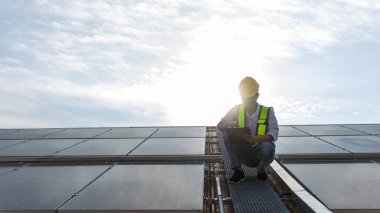 Engineer working setup Solar panel at the roof top. Engineer or worker work on solar panels or solar cells on the roof of business building clipart