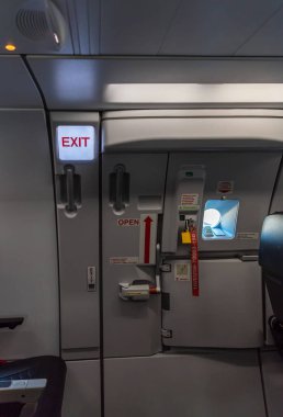 Yolcu uçağında çıkış tabelası. Uçakta acil çıkış tabelası. Çıkış işareti.