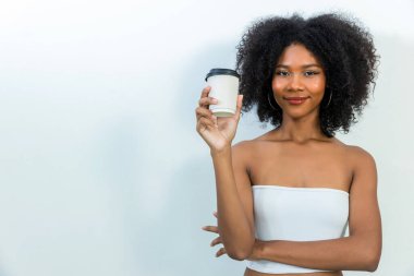 Joyful young woman enjoying a cup of coffee at home. woman holding coffee paper cup