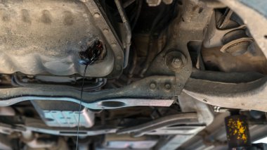 Motordaki eski yağı boşaltım kapsülünden boşalt. Araba motorunun yağını değiştirmek. Motorlu araçtan atık yağ boşaltımı. Kullanılan dizel motor gücünü yağ tavasından bir konteynıra boşaltma