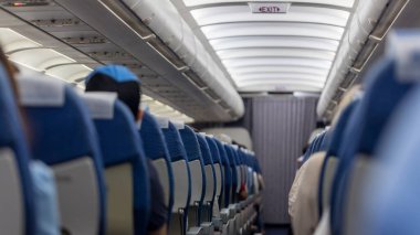 Passenger seat. Interior of airplane with passengers sitting on seats. Plane cabin. The interior of the aircraft with passengers on seats.