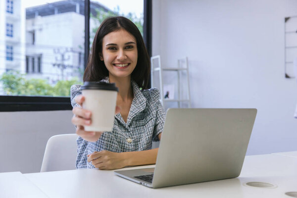 Happy woman working at the office with cups of coffee. businesswoman drinking coffee