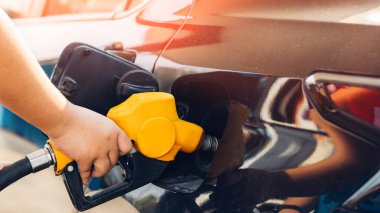 Benzini istasyonda doldur ve doldur. Benzin istasyonu, yakıt ikmali. Makineyi yakıtla doldurmak için. Benzin istasyonunda benzinle dolu bir araba. Benzin istasyonu pompası.