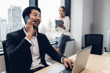 Call center business woman talking on headset. Call center worker accompanied by her team. Customer service executive working at office.	