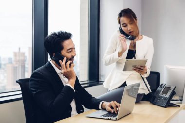 Call center business woman talking on headset. Call center worker accompanied by her team. Customer service executive working at office.	