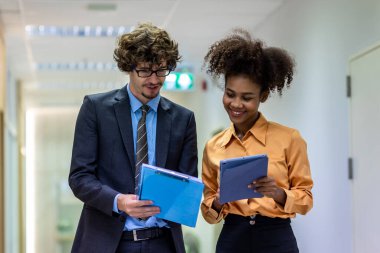 Çeşitli arkadaş ortaklar modern ofis koridorlarında yürümekten bahseder. Ofiste yürüyen ve konuşan kendine güvenen iş ortakları. Profesyonel iş adamları yürüyor ve konuşuyor.