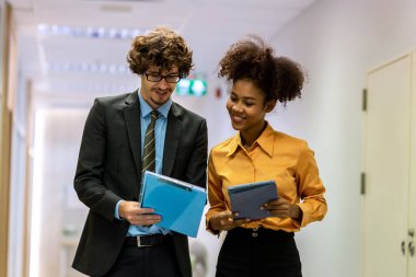 Çeşitli arkadaş ortaklar modern ofis koridorlarında yürümekten bahseder. Ofiste yürüyen ve konuşan kendine güvenen iş ortakları. Profesyonel iş adamları yürüyor ve konuşuyor.