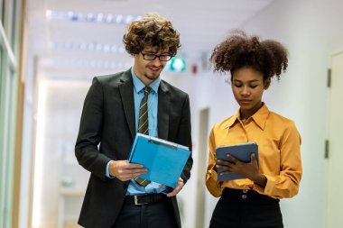 Çeşitli arkadaş ortaklar modern ofis koridorlarında yürümekten bahseder. Ofiste yürüyen ve konuşan kendine güvenen iş ortakları. Profesyonel iş adamları yürüyor ve konuşuyor.