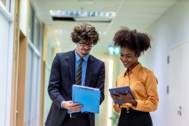 Çeşitli arkadaş ortaklar modern ofis koridorlarında yürümekten bahseder. Ofiste yürüyen ve konuşan kendine güvenen iş ortakları. Profesyonel iş adamları yürüyor ve konuşuyor.
