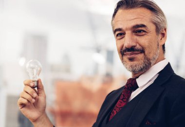 Elinde ampul tutan bir iş adamı. Yenilikçi ve ilham verici bir fikir. İş adamı elinde ampul tutuyor. Beyin yaratıcı düşünceler ve yenilik kavramı.