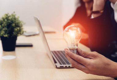 Elinde ampul tutan bir iş adamı. Yenilikçi ve ilham verici bir fikir. İş adamı elinde ampul tutuyor. Beyin yaratıcı düşünceler ve yenilik kavramı.