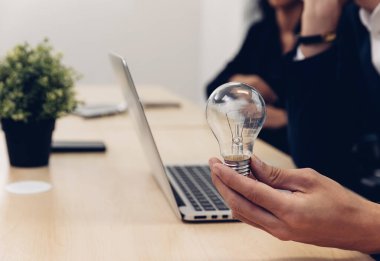 Elinde ampul tutan bir iş adamı. Yenilikçi ve ilham verici bir fikir. İş adamı elinde ampul tutuyor. Beyin yaratıcı düşünceler ve yenilik kavramı.