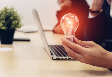 Elinde ampul tutan bir iş adamı. Yenilikçi ve ilham verici bir fikir. İş adamı elinde ampul tutuyor. Beyin yaratıcı düşünceler ve yenilik kavramı.