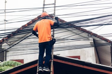 Ahşap merdivendeki teknisyen Fiber Optik Kabloları kontrol ediyor. Merdivendeki teknisyen dijital kablo sistemini kontrol et ve kaldır