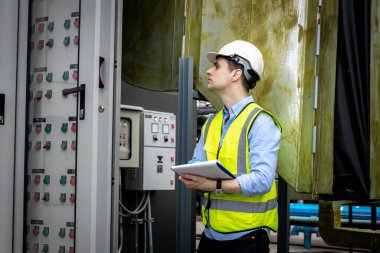 Electrical engineer working in control room. Electrical engineer man checking Power Distribution Cabinet in the control room