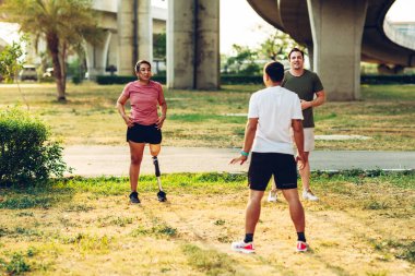 Arkadaş, dışarıda egzersiz yaparken protez bacaklı arkadaşına destek oluyor. İnsanlar parkta birlikte yürüyorlar. Yürüyüş egzersizi yapan protez bacaklı kadın ve arkadaşı parkta birlikte destek oluyor.