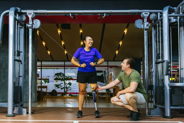 理学療法士は彼女の患者と義肢を世話する 理学療法士は スポーツセンターで義肢装具士の女性を支援します 理学療法士と患者と一緒にリハビリとジム — ストック写真