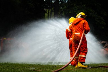 Firefighter Concept. Fireman using water and extinguisher to fighting with fire flame. firefighters fighting a fire with a hose and water during a firefighting training exercise