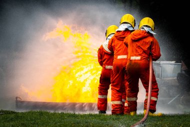 Firefighter Concept. Fireman using water and extinguisher to fighting with fire flame. firefighters fighting a fire with a hose and water during a firefighting training exercise