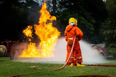 Firefighter Concept. Fireman using water and extinguisher to fighting with fire flame. firefighters fighting a fire with a hose and water during a firefighting training exercise