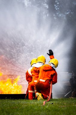Firefighter Concept. Fireman using water and extinguisher to fighting with fire flame. firefighters fighting a fire with a hose and water during a firefighting training exercise