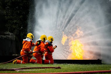 Firefighter Concept. Fireman using water and extinguisher to fighting with fire flame. firefighters fighting a fire with a hose and water during a firefighting training exercise