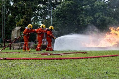 Firefighter Concept. Fireman using water and extinguisher to fighting with fire flame. firefighters fighting a fire with a hose and water during a firefighting training exercise