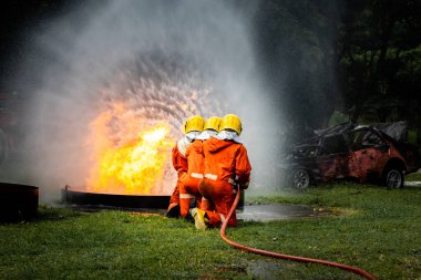 Firefighter Concept. Fireman using water and extinguisher to fighting with fire flame. firefighters fighting a fire with a hose and water during a firefighting training exercise
