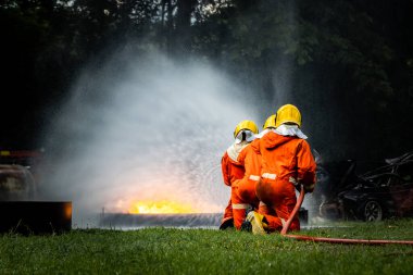 Firefighter Concept. Fireman using water and extinguisher to fighting with fire flame. firefighters fighting a fire with a hose and water during a firefighting training exercise