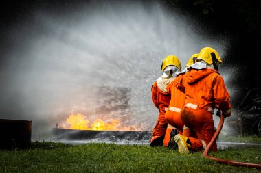 Firefighter Concept. Fireman using water and extinguisher to fighting with fire flame. firefighters fighting a fire with a hose and water during a firefighting training exercise