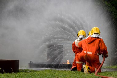 Firefighter Concept. Fireman using water and extinguisher to fighting with fire flame. firefighters fighting a fire with a hose and water during a firefighting training exercise