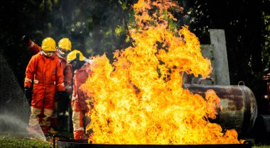 Firefighter Concept. Fireman using water and extinguisher to fighting with fire flame. firefighters fighting a fire with a hose and water during a firefighting training exercise