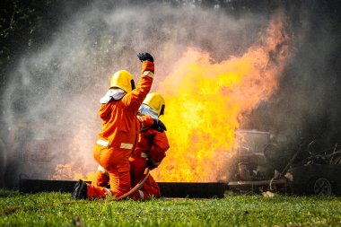 Firefighter Concept. Fireman using water and extinguisher to fighting with fire flame. firefighters fighting a fire with a hose and water during a firefighting training exercise
