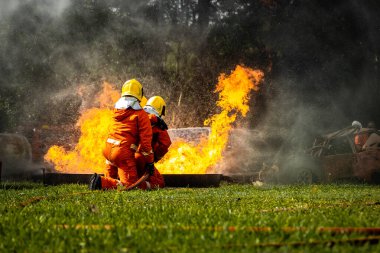 Firefighter Concept. Fireman using water and extinguisher to fighting with fire flame. firefighters fighting a fire with a hose and water during a firefighting training exercise