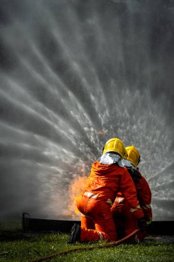 Firefighter Concept. Fireman using water and extinguisher to fighting with fire flame. firefighters fighting a fire with a hose and water during a firefighting training exercise